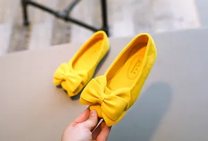 Detailansicht gelber Kinder-Flachschuhe mit einer weichen Wildleder-Schleife und Passform
