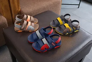 Collection of multi-colored children's summer sports sandals displayed on a leather stool