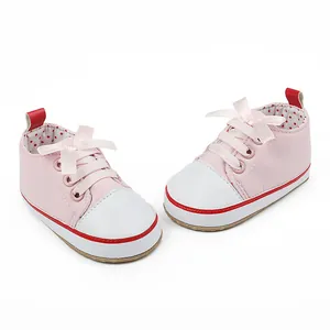 Detailed view of pink baby girl walking shoes with white toe and silk bow laces