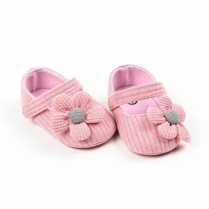 Detailed view of pink knitted baby shoes featuring 3D flower and soft walking sole