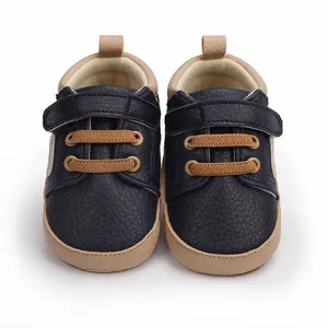 Detail of navy blue infant pre-walker shoes with hook-and-loop strap and brown laces.