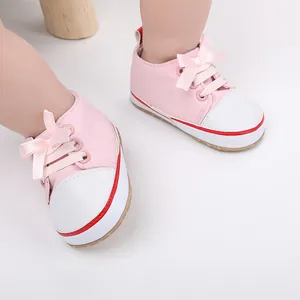 Detail of pink and white baby girl walking shoes with soft ribbon laces for 0-1 year old