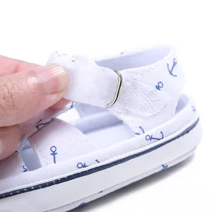 Close-up of baby walking sandal with adjustable Velcro strap and blue anchor pattern