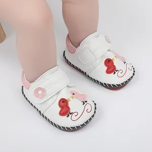 Primer plano de zapatos de bebé cosidos a mano con bordado de pájaro y suela antideslizante