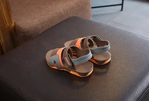 Detailed view of kids' sports sandals with orange soles and adjustable straps.