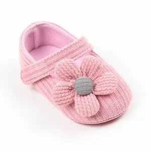 Detailed close-up view of pink knitted baby princess walker shoe with large flower