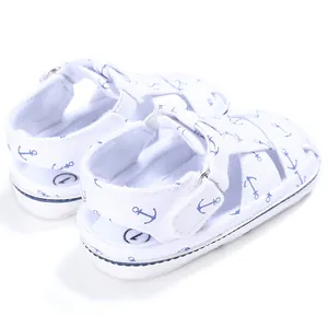 Close-up detail view of baby walking sandals with blue anchor print on white canvas