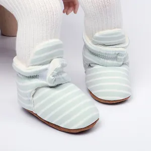 Gros plan sur des bottes d'hiver rayées pour bébé avec une doublure en polaire chaude