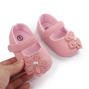 Dettaglio delle scarpe primi passi rosa per neonata con fiore 3D e decorazione di perle