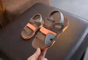 Close-up of brown and orange boys beach sandals with velcro strap