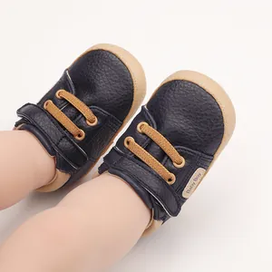 Detail of navy blue baby pre-walker shoes with leather texture and Baby Boy label