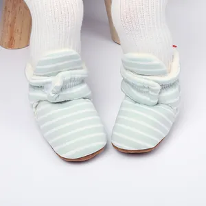 Détail des bottines d'hiver rayées bleu clair pour bébé avec doublure en polaire.