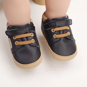 Detail of navy blue baby walking shoes with Velcro strap and tan elastic laces