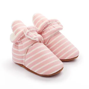 Détail de bottes d'hiver pour bébé rayées rose et blanc avec doublure polaire chaude