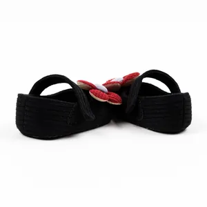 Detailed back view of black knit baby princess shoes with 3D red flower decoration