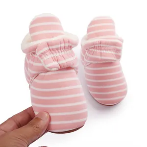 Gros plan de bottes d'hiver roses à rayures pour bébé avec doublure en polaire blanche
