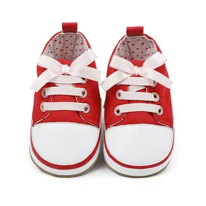 Detail view of red canvas baby girl walking shoes with soft pink ribbon bow laces