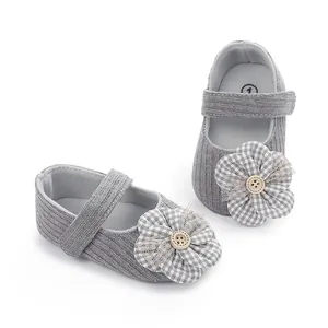 Primer plano de zapatos de princesa para bebé en punto gris con flores de cuadros