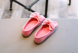 Detailansicht der rosafarbenen Mädchen-Prinzessin-Schuhe mit großen Schleifen und Wildleder.