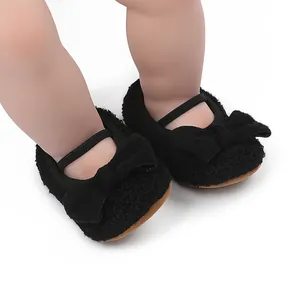 Primer plano de zapatos de bebé negros suaves con detalle de lazo y correa elástica