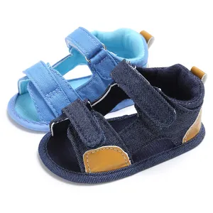 Close-up of denim baby sandals with hook-and-loop straps in navy and light blue colors