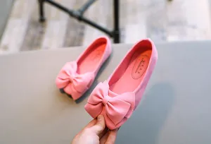 Nahaufnahme von rosafarbenen Wildleder-Ballerinas für Mädchen mit einer großen Schleife.