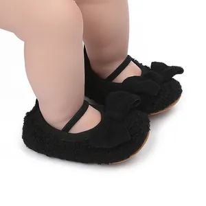 Primer plano de zapatos de bebé negros peludos con lazo para recién nacidos