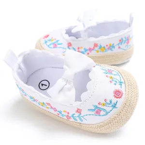Detail van witte babyprinsessenschoenen voor meisjes met kleurrijk bloemborduursel