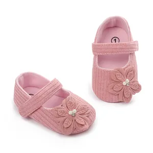 Vista dettagliata delle scarpe da principessa rosa per neonati con un grande fiore