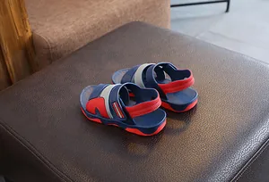 Detailed side and rear view of navy blue and red children's summer sandals on brown leather