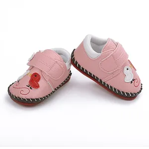 Primer plano de zapatos de bebé rosa con bordado de dibujos y suela de goma antideslizante