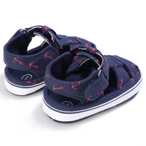 Detailed back view of navy blue baby walking sandals with cute red anchor prints