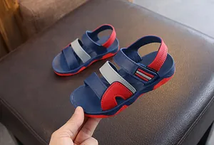 Side detail view of boys blue and red sporty beach sandals with hook and loop straps