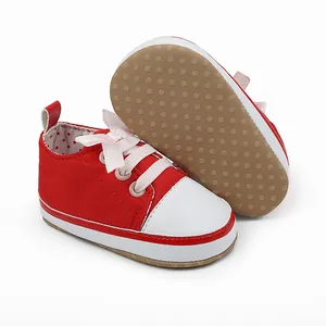 Close-up detail of red baby girl pre-walker shoes with non-slip soles and pink bow