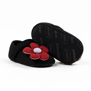 Detail view of black knit baby girl princess walking shoes with red flower decoration