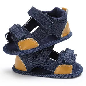 Close-up of denim baby sandals with adjustable velcro straps and brown leather accents