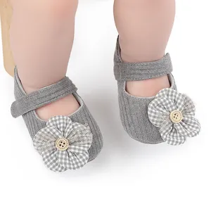 Primer plano detallado de zapatos grises para bebé con flor a cuadros y botón de madera