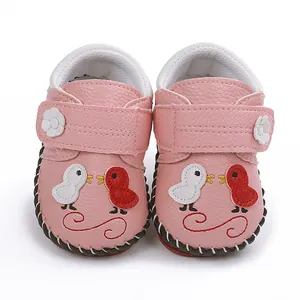 Vista detallada de zapatos rosas para bebé con bordado de pajaritos