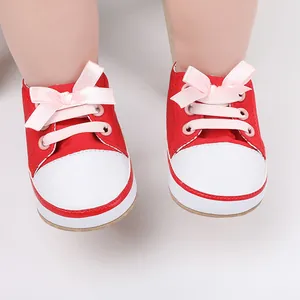 Detailed close-up of red canvas baby pre-walker shoes featuring cute pink ribbon bow ties