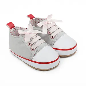 Adorable grey canvas baby girl walking shoes featuring pink ribbon bows and red trim details