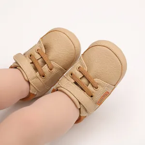 Close-up detail of khaki infant walking shoes with Baby Boy tag and velcro strap