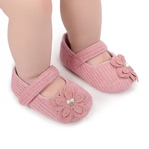 Primo piano di scarpe da principessa per neonati rosa con dettaglio floreale in tessuto