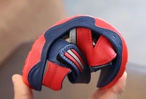 Flexible sole of red and navy blue children's summer sandals showing durability