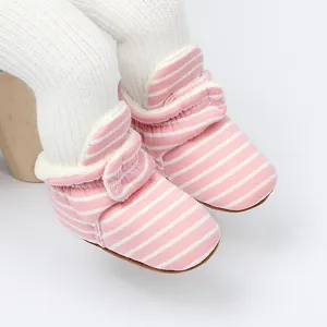 Gros plan sur les bottines d'hiver rayées roses et blanches avec doublure polaire.