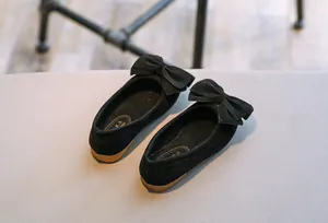 Nahaufnahme von schwarzen Mädchen-Prinzessinenschuhen aus Samt mit Schleife.