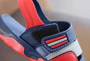 Detail shot of blue and red boys beach sandal showing durable velcro strap and stitching