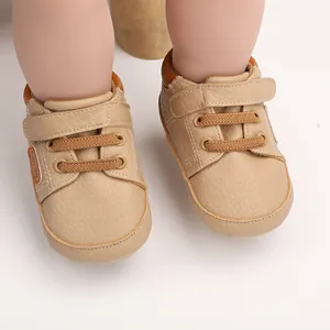 Macro detail of khaki leather baby walking shoes with Baby Boy tag and velcro strap