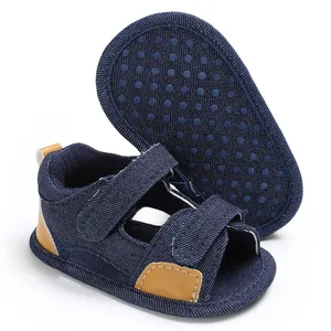 Close-up detail of navy denim baby sandals featuring anti-slip dotted sole and Velcro straps