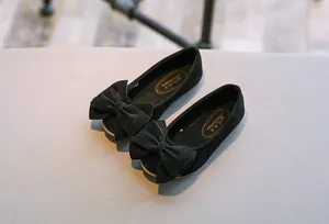 Nahaufnahme von eleganten schwarzen Wildleder-Ballerinas für Mädchen mit Schleife