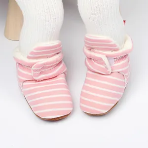 Gros plan détaillé de bottines d'hiver roses à rayures pour bébé avec doublure en polaire
